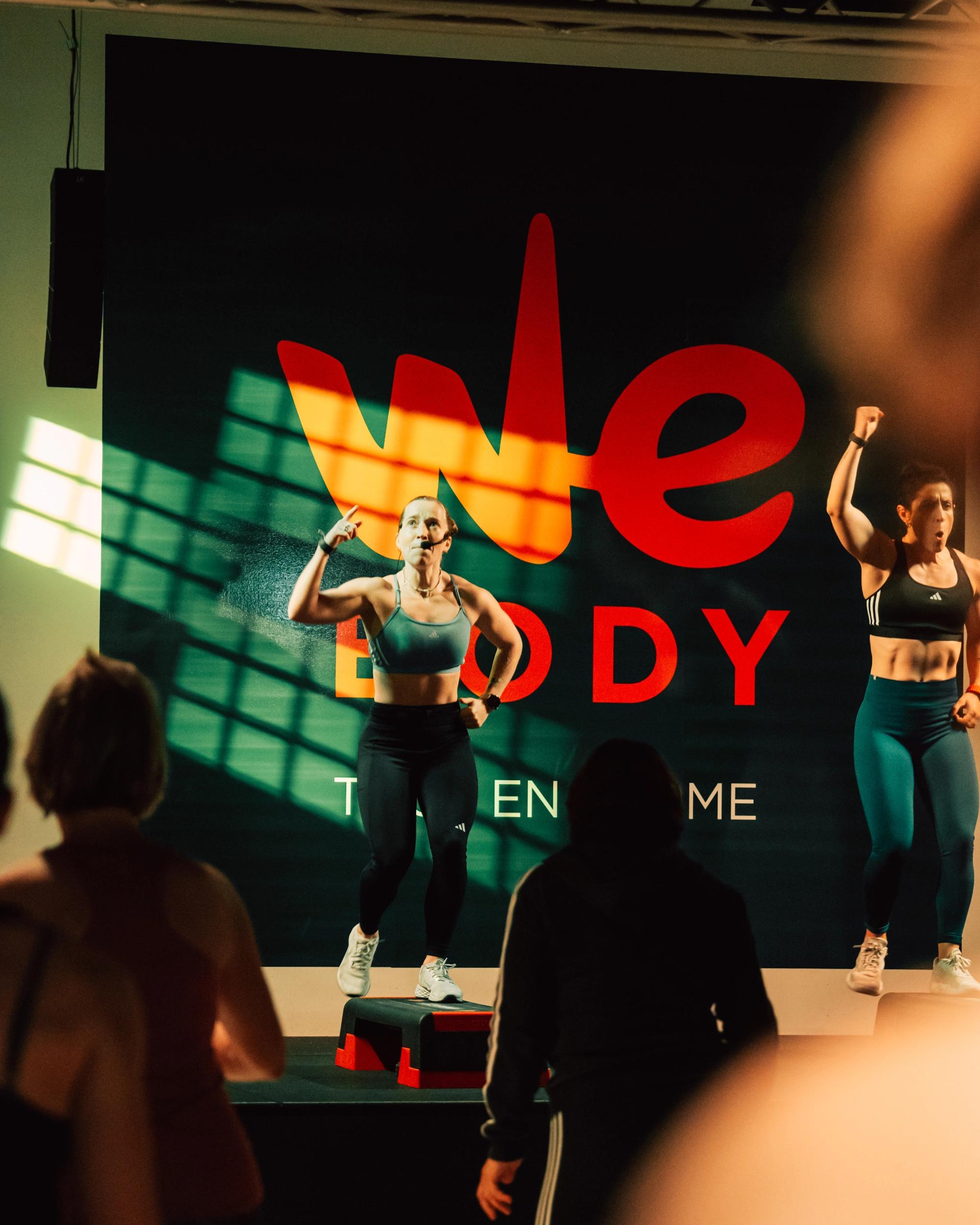 L'équipe de Webody anime une séance de fitness dynamique sur scène devant un public enthousiaste